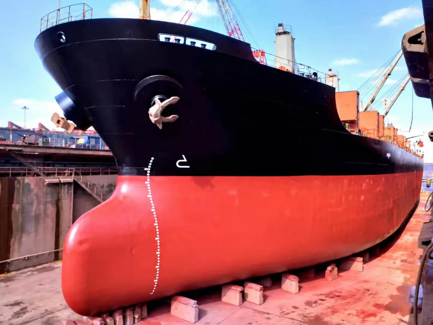Bow maintenance on a black-hulled vessel